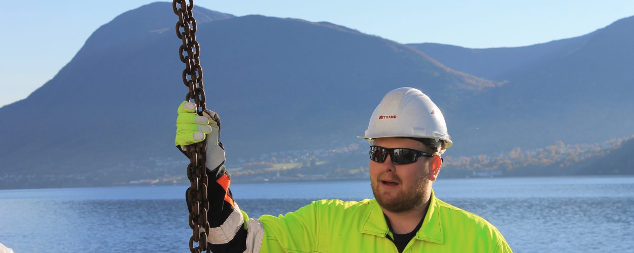 Kranførar i arbeid ved fjorden